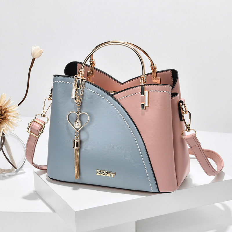 Colour block handbag with heart tassel